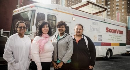 Four female Project Renewal staff stand in front of a medical van